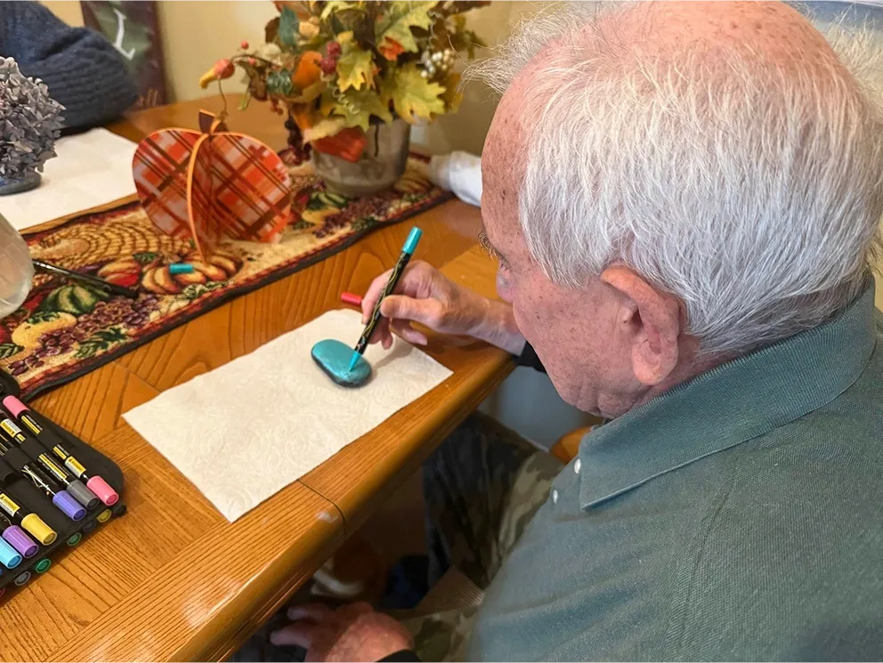 Resident in senior care home in Vancouver WA painting a rock
