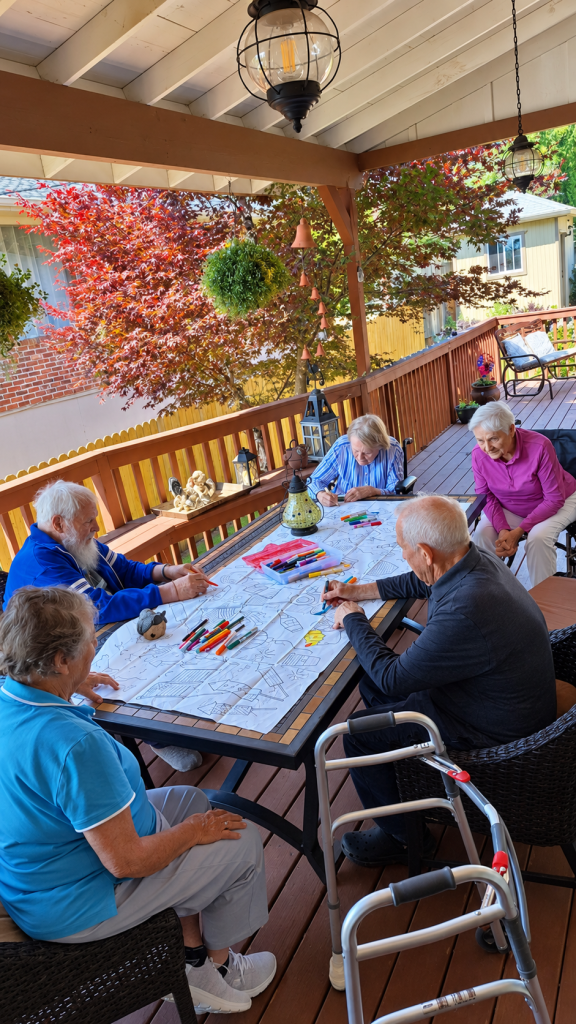 Five older adults coloring on a porch