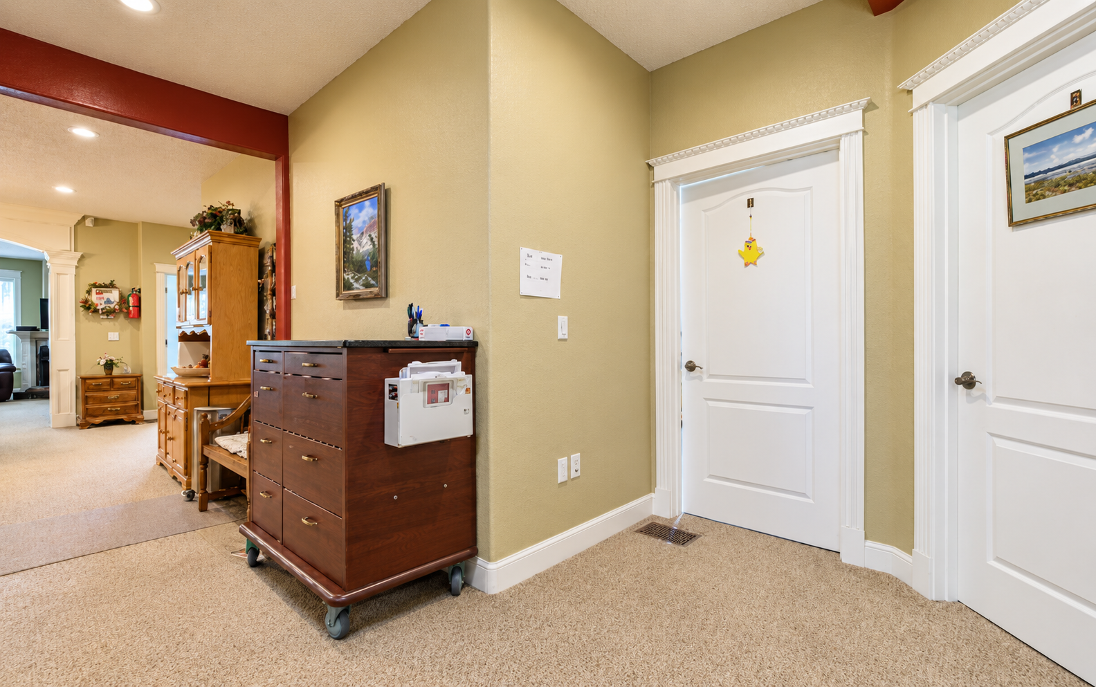 Warm hallway with ornate doors and cabinet